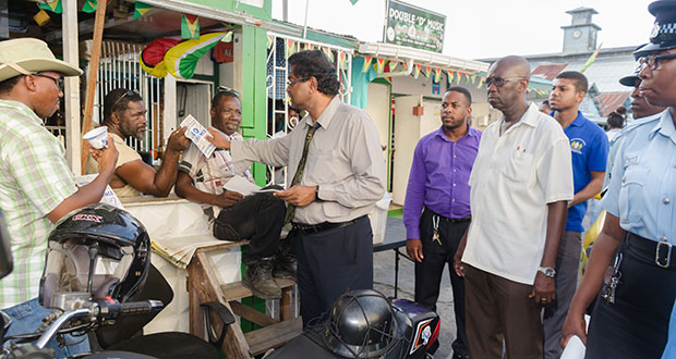 Minister of Public Security Khemraj Ramjattan interacts  with vendors/citizens about  TIP on Thursday afternoon during the  Bourda Market walkabout.