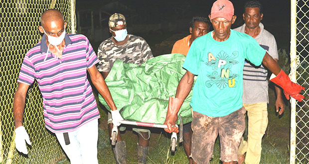 Undertakers remove the body of 19-year-old Harris Anthony Persaud, who washed up on the western foreshore of Garden of Eden, East Bank Demerara. [Ivan Bentham photo]