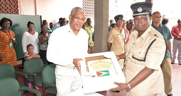 President David Granger receiving, from a representative of the Guyana Police Force (GPF), a cake with the Guyana Flag and the Presidential Standard symbol
