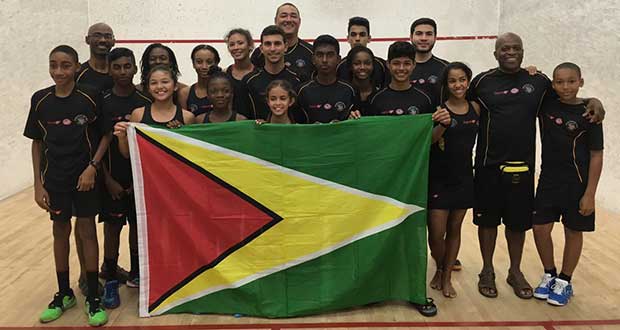 Winners! The winning Guyana Junior Squash team lifting the Golden Arrowhead, with team coach Carl Ince (second from right), and other officials