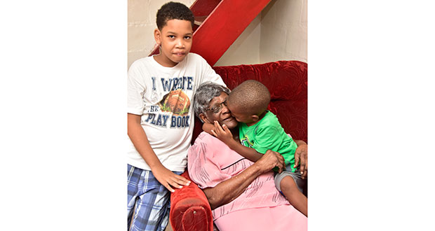 ‘Granny Agnes’ being shown affection by her great grandchildren Joshua Ogele [left] and Denzel Clarke [right].