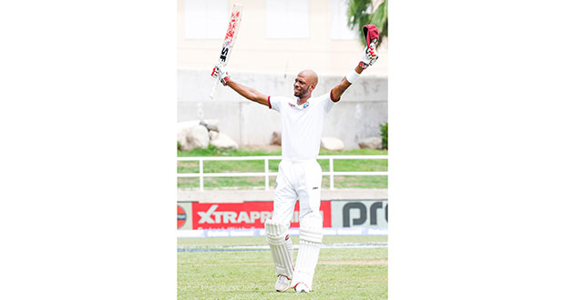 Roston Chase raises his bat after bringing up his maiden Test hundred © WICB Media Photo/Athelstan Bellamy
