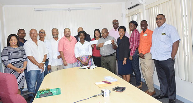 Minister of Natural Resources Raphael Trotman and acting GGMC commissioner Newell Dennison (standing in the back) with Closed Areas Committee officials and several small miners who were present to receive their claims