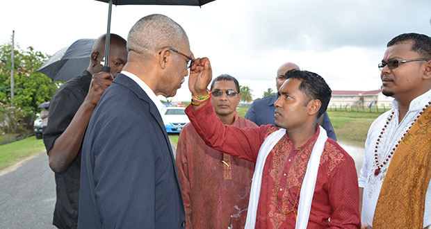 A member of the Blairmont Mandir applying the chandan tika on President David Granger's forehead upon his arrival at the prana pratistha ceremony of the Lord Hanuman Murti