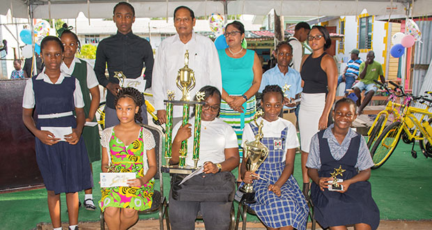Prime Minister Moses Nagamootoo and his wife, Mrs. Sita Nagamootoo flanked by students who received prizes along with Influential Millennial representative (extreme right standing)