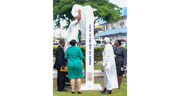 The Peace Pole is being unveiled by Prabhupada Deva Prabhu, while City Mayor Patricia Chase-Greene (left), Dr. Eton Simon (left), Sherry Jerrick (right) and a religious leader look on