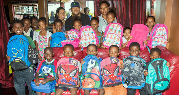 Kerwin Adams [centre,back row] poses with students of the Tucville Primary School as they show off their gifts