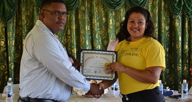 Region One Chairman Mr. Brentnol Ashley presents a certificate to Ms Nevita Poliah, who said that she intends to use her newly acquired knowledge to open an electronics business. (Ministry of the Presidency photo)