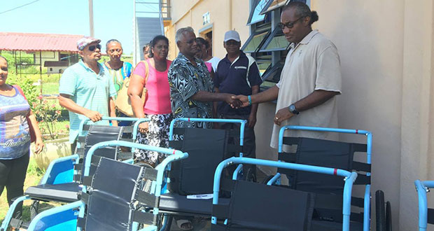 President of St Francis, Alexis Foster hands over the wheelchairs to family members of the recipients