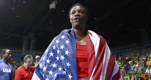 Claressa Shields (USA) of USA wears her national flag as she celebrates after winning her bout. REUTERS/Peter Cziborra