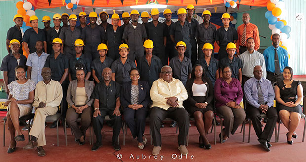 Social Protection Minister Volda Lawrence bordered by Minister Keith Scott on the left and BIT Chairman Clinton Williams on the right. Also in photo are graduates of the Heavy Duty Equipment Training Programme and representatives of the programme