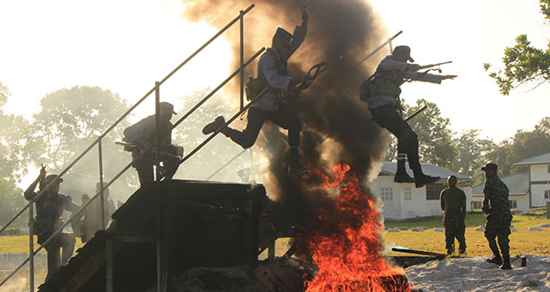 Officers attached to the Guyana Defense Force (GDF) brave the blazing fire to complete the obstacle course on Friday during the force’s third quarterly fitness competition which was held at Base Camp Stephenson.[Ravin Singh photo]