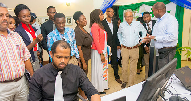 Education Minister, Dr Rupert Roopnaraine (second right) and other ministry officials being briefed by BrainStreet Group Chief Executive Officer, Lance Hinds on animation projects following the launch of the programme last July