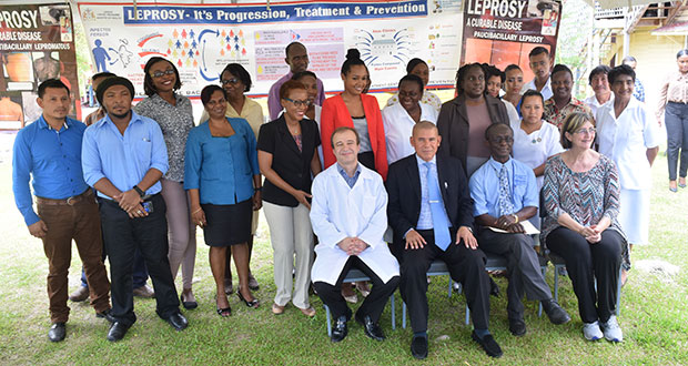 Public Health Minister, Dr. George Norton and PAHO Country Representative, Dr. William Adu-Krow (in the center) sounded by the key facilitators and participants of the workshop