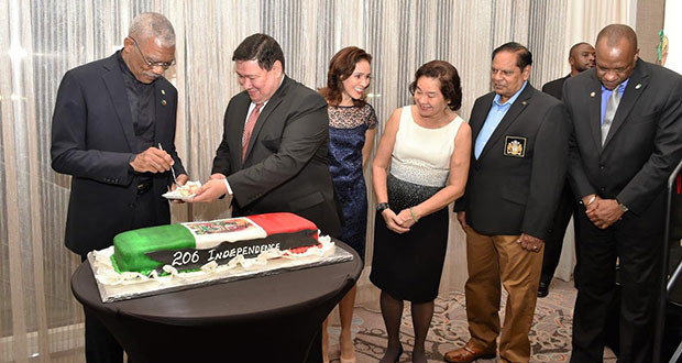 President David Granger cuts the cake with Mexican Ambassador Ivan Roberto Sierra-Medel as part of the Independence celebrations. They are accompanied by First Lady Mrs. Sandra Granger, Prime Minister Mr. Moses Nagamootoo, Minister of State Mr. Joseph Harmon, and the Ambassador's wife, Ms. Norma Alizia de la Torre Diaz