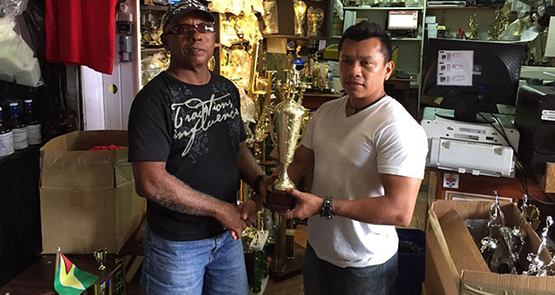 Trophy Stall owner Ramesh Sunich hands over the winner’s trophy to a GAPLF representative.
