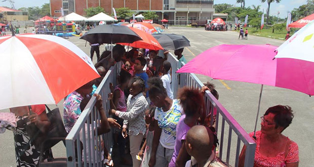 Children queue  at the National Cultural Centre tarmac to benefit from Digicel’s back-to-school outreach