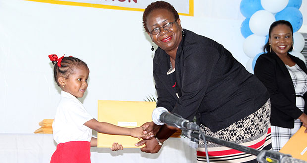 Glenna Vyphius, Chief Schools Welfare Officer,  presents a certificate to a student. (Ministry of Education photo)