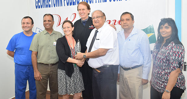 Dr. Carl Max Hanoman presents a token of appreciation to Dr. Joanna Cole, Consultant, Internal Medicine, whose contract came to an end on October 1.  Others, from left, are Dr. Rodrigo Soto, Dr. Sheik Amir, Dr. Clint Doiron, Mr. Michael Khan and Dr. Merissa Seepersaud (Cullen Bess-Nelson)