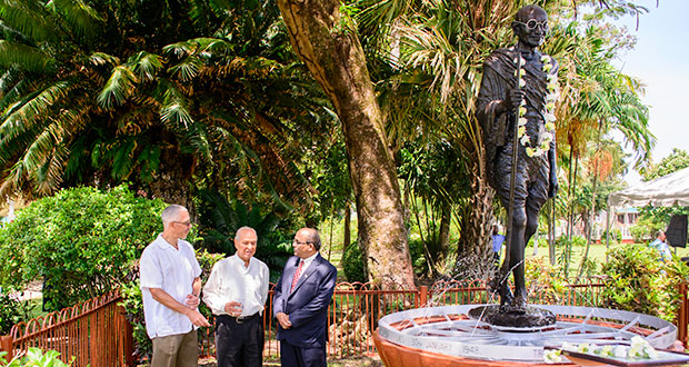 Minister of Business and Tourism, Dominic Gaskin; Dr. Yesu Persaud; and Indian High Commissioner to Guyana, Venkatachalam Mahalingam, discussing the life of Mahatma Gandhi beside his monument