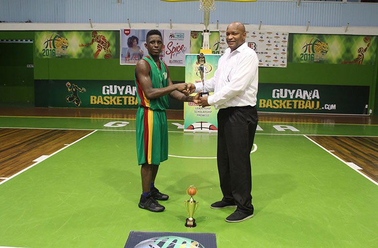 Stanton Rose (left) receives NSBF MVP trophy from Guyana Amateur Basketball Federation president Nigel Hinds.