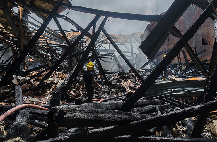 A fireman walks through the rubble
in the burnt-out bond at Gafoors