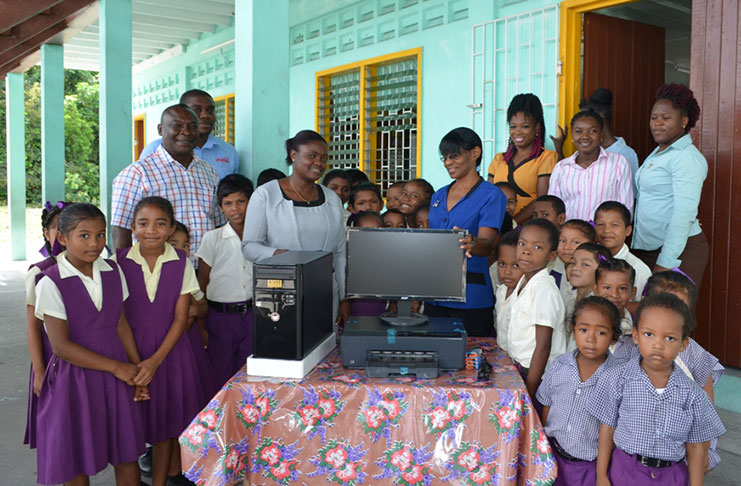 Banks DIH’s Linden branch manager, Ms Shondell Easton (right of computer) makes the presentation to the school’s headmistress, Ms. Denise Piggott