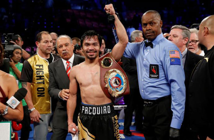 Manny Pacquiao celebrates his victory over WBO welterweight champion Jessie Vargas following their title fight at the Thomas & Mack Center in Las Vegas, Nevada, U.S., Saturday. Referee Kenny Bayless is at right. REUTERS/Las Vegas Sun/Steve Marcus