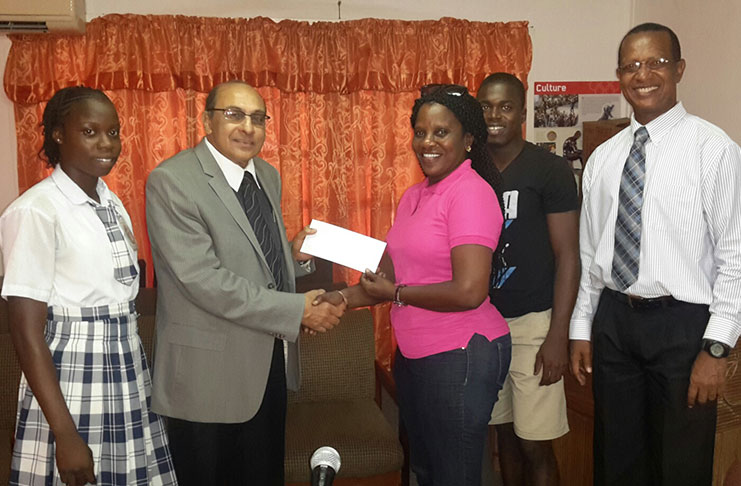 GOA President, K. A Juman-Yassin (second left), hands over the sponsorship to team manager Mayfield Taylor-Trim.  They are flanked by, from left, athletes Kenisha Phillips and Tyrell Peters, and AAG President, Aubrey Hutson