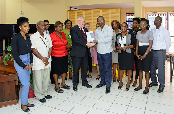 High Commissioner of Canada to Guyana, Pierre Giroux handing over law books to Vice-Chancellor, Professor Ivelaw Griffith surrounded by staff and students of law of the University of Guyana