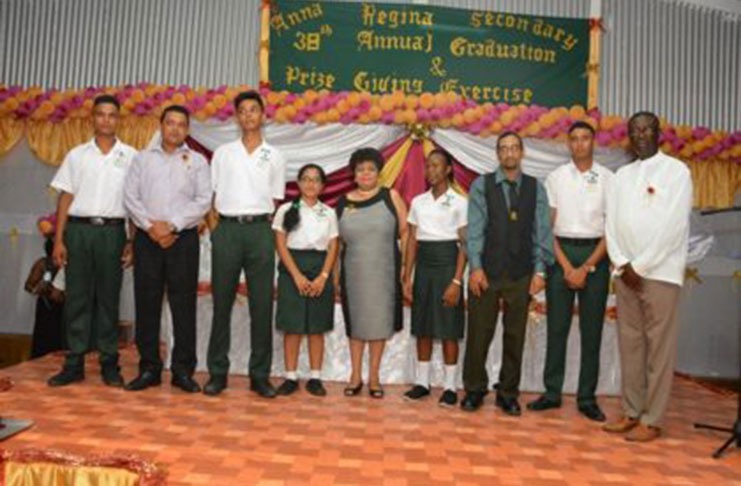 Social Cohesion Minister Amna Ally and regional officials pose with teachers of the Anna Regina Secondary School and the top five students at the 2016 CSEC examinations