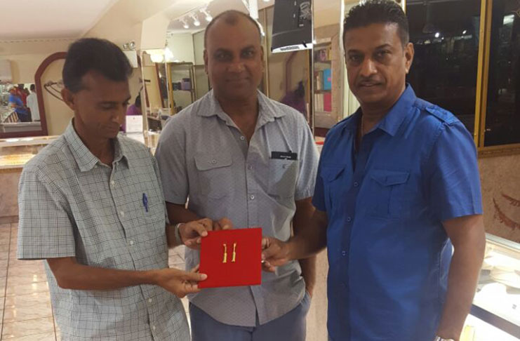 L-R Dharam Persaud, Ricky Deonarain and Steve Naraine holding pendants