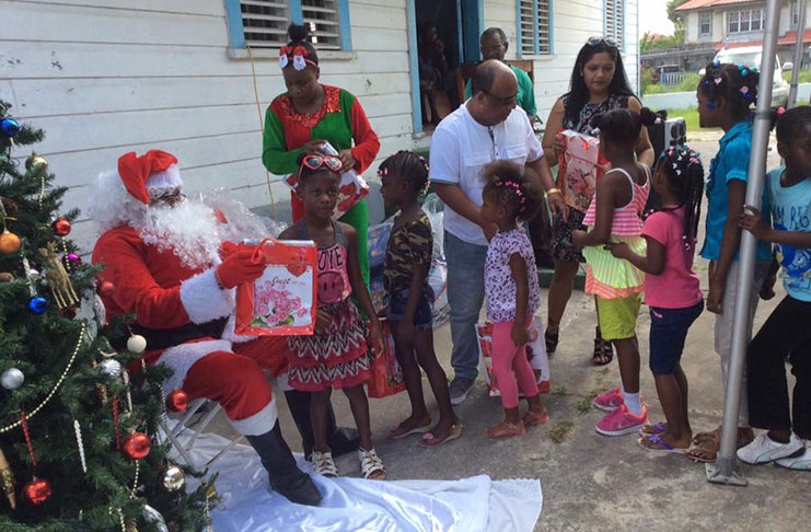 Santa distributes toys to the little girls and boys