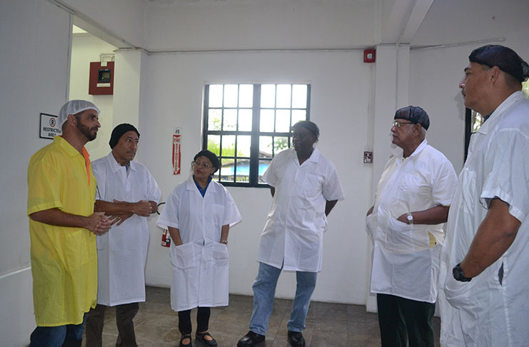 Agriculture Minister Noel Holder and his team listen to Peter De Groot , Managing- Director of Bounty Farm Limited and David Fernandez during a tour of the Timehri facility.