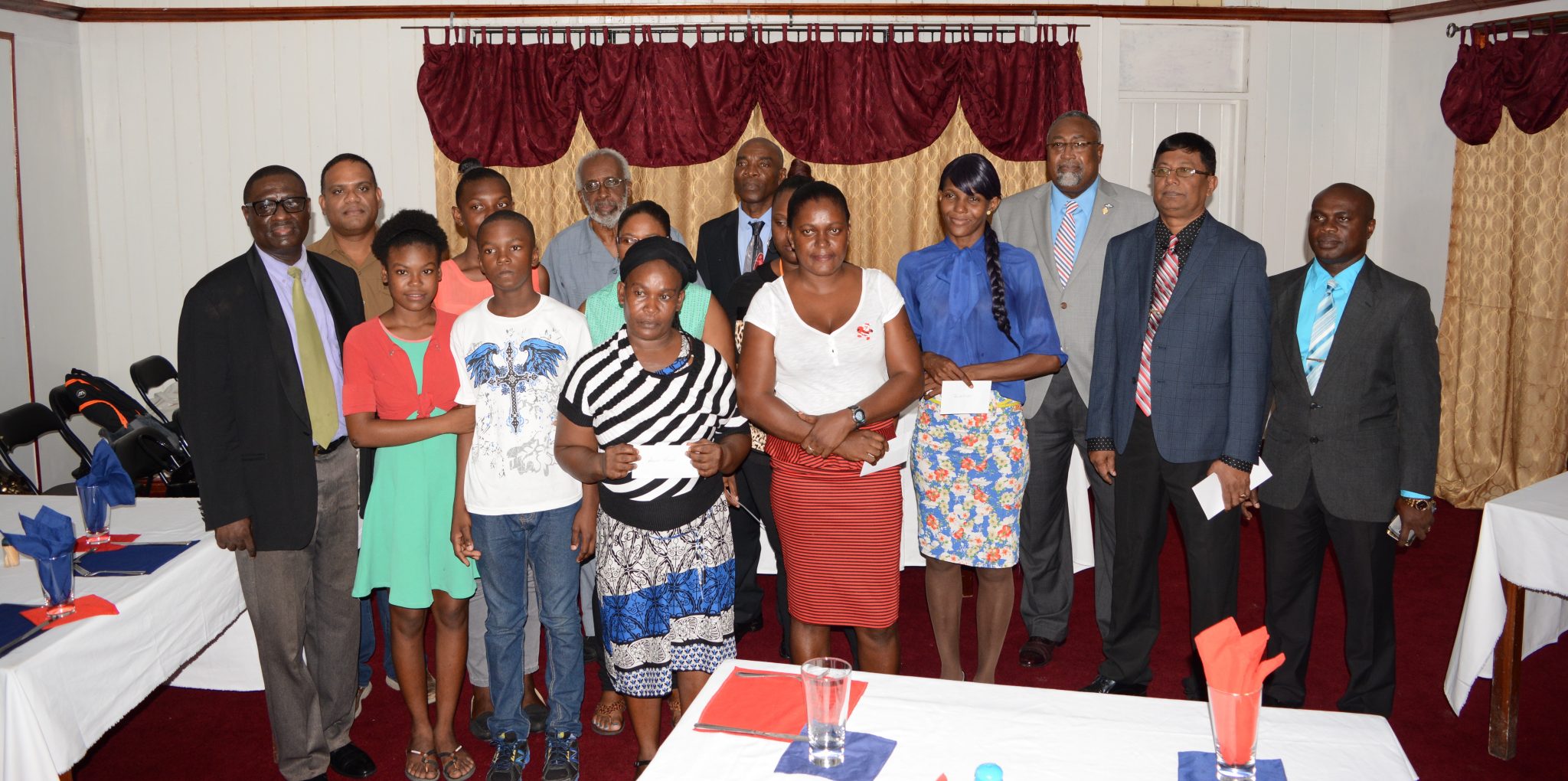 Some of the recipients of the Guyana Police Force Fallen Heroes Foundation Inc flanked by the members of the foundation.