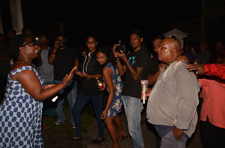 An APNU+AFC supporter passionately makes a point to a visibly angry PPP/C supporter on Friday night during a counter-vigil held outside of the Red House, High Street, Kingston. Also in photo are several media representatives. (Delano Williams photo)