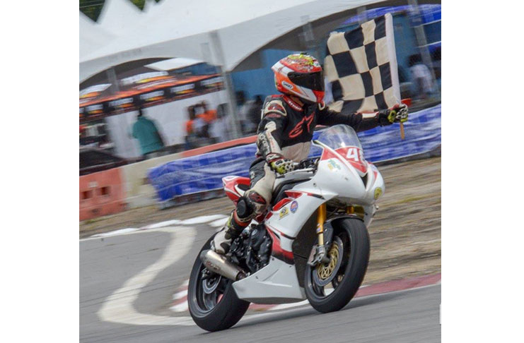 Matthew Vieira waves the chequered flag in Trinidad (A Mikey Spice Photo)