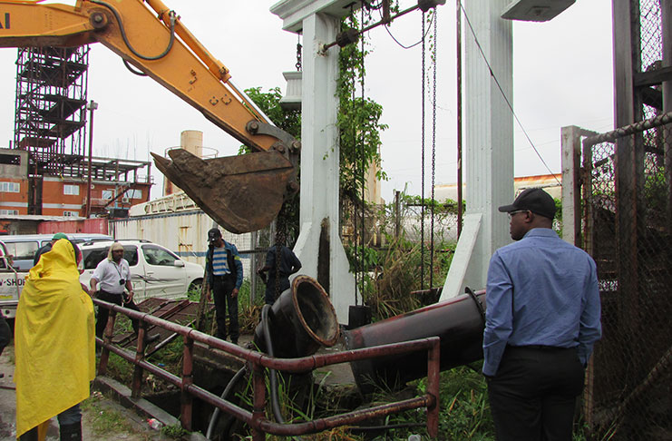 Works being carried out on the Cowan Street pump on Friday afternoon. At right, Minister of Public Infrastructure, David Patterson, assesses the work.
