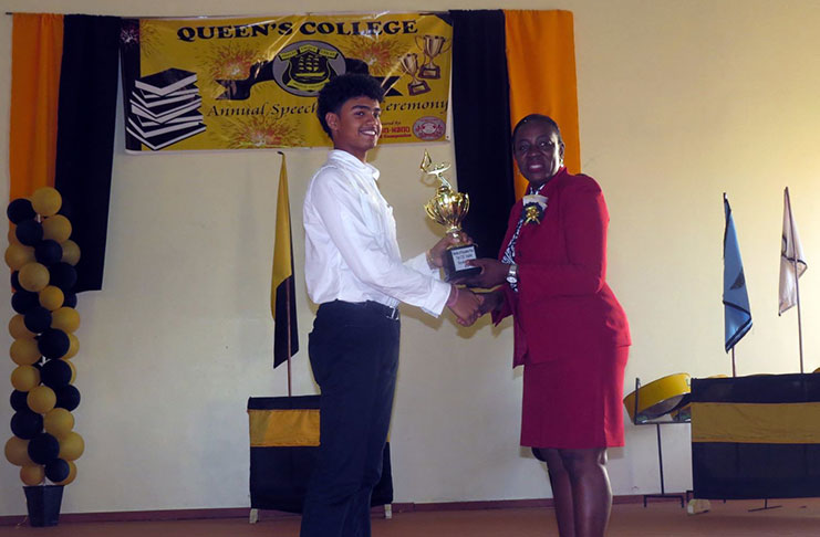 QC’s top performer Kayshav Tewari receiving his award for obtaining 19 Grades Ones at this year’s CSEC Examinations from Minister Henry
He also received awards for being the Caribbean’s Best Science Performer; for being the Region’s overall Top Performer; and for ranking among the Caribbean’s top 10 performers in five individual subjects (Photo courtesy of Lictor Live)