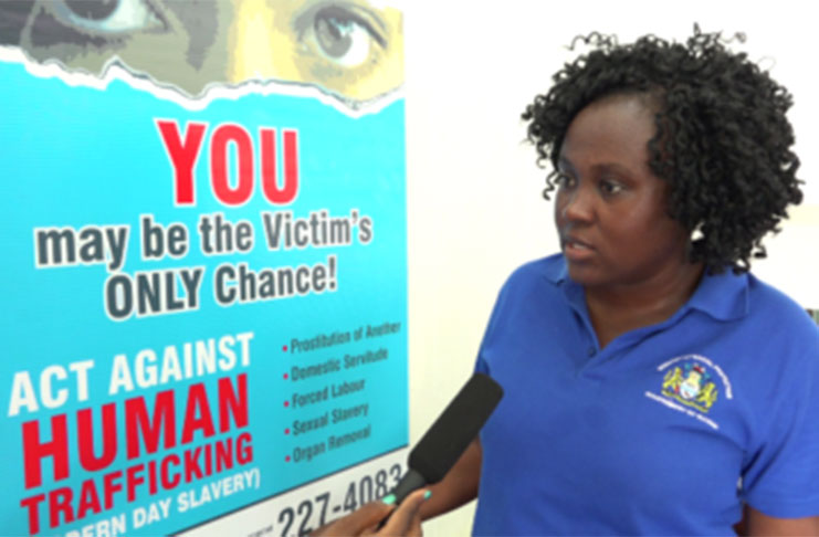 Acting Coordinator of the C-TIP Unit, Tanisha Williams-Corbin, displaying the banner that would be used to create awareness at key areas in the fight against human trafficking