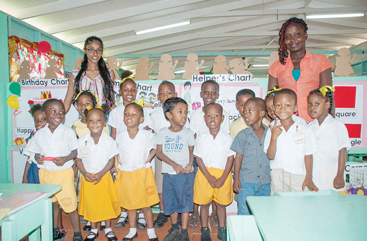 Pictured are the St. Christopher first year nursery schoolers. Behind them, on the left is Surujdai Mukhram (EPIC Guyana Program Coordinator) and on the right is Ms. Jinelle Washington (St. Christopher Teacher).