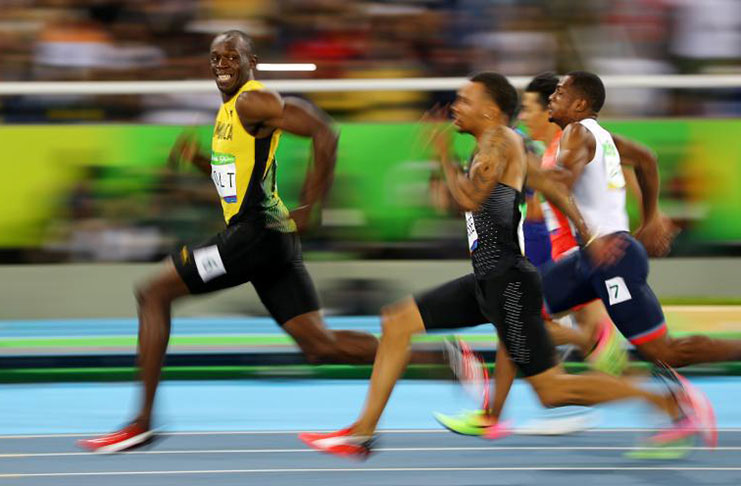 Usain Bolt of Jamaica turns to look at Andre De Grasse of Canada as they compete in the men's 100m semifinals at the 2016 Rio Olympics in Brazil, August 14, 2016. (REUTERS/Kai Pfaffenbach)