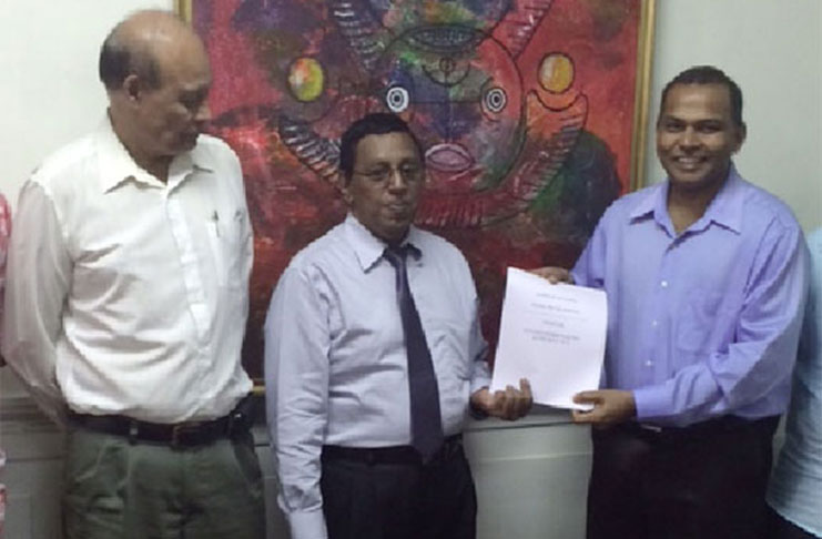 Flashback! Legal Adviser of the Guyana Horse Racing Authority (GHRA) Rajendra Poonai (centre) hands over the draft legislation to the-then Minister of Sport Dr Frank Anthony in the presence of GHRA president Vickram Ouditt.