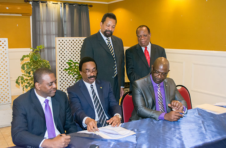 Attorney General (AG) and Minister of Legal Affairs, Basil Williams SC, signs the Memorandum of Understanding (MoU) to bring into effect formal arrangements to commence  establishment of the law school. He is flanked by Mr. Courtney Wynter (left), Chairman, Law College of the Americas (LCA); Dr Winston Adams, Group Executive Chairman, University College of the Caribbean (UCC); (standing from left) Professor Dennis Gayle, Executive Chancellor, UCC; and Dr Trevor Hamilton, Advisor on the law school venture