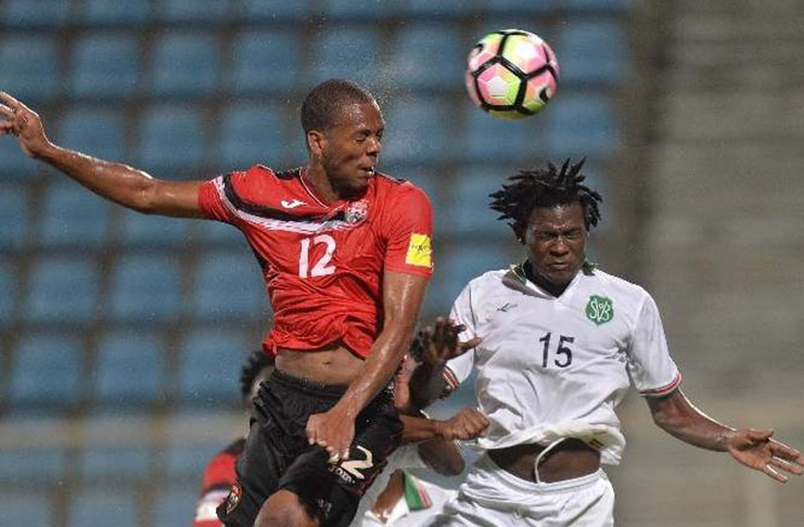 T&T's Carlyle Mitchell, left, rises above Suriname's Miquel Darson while contesting a header during action from Wednesday night's clash.