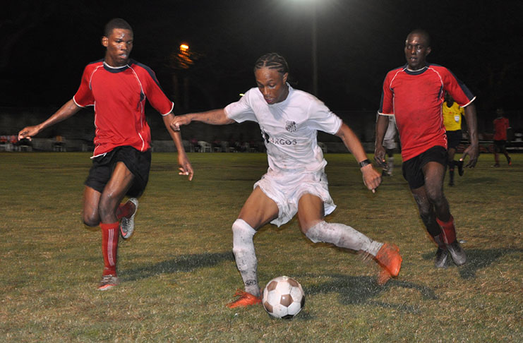 Santos’ Job Caesar battles his way past two Riddim Squad players on Sunday night at the GFC ground.