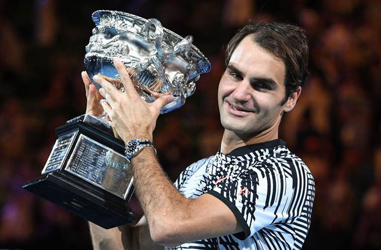 Roger Federer celebrates with the championship trophy during the awards ceremony after his Australian Open victory in Melbourne.