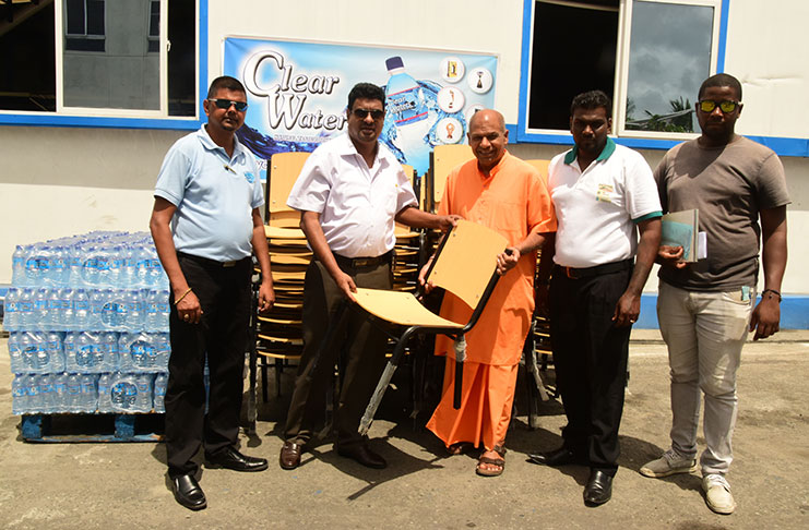 Owner of Clear Waters, Lloyd Singh (second from left) hands over of one of the chairs to Swami Aksharananda