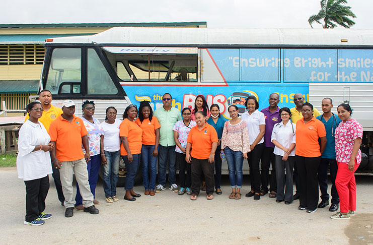 Olive Gopaul poses with the Team of Doctors and other health workers near the Rotary Club Dental Bus (Samuel Maughn photo)