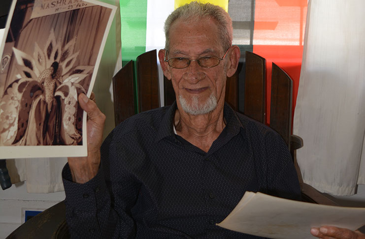 The man who helped coined the word “Mashramani” holds up one of the pictures of the first ever Miss Mashramani contest.